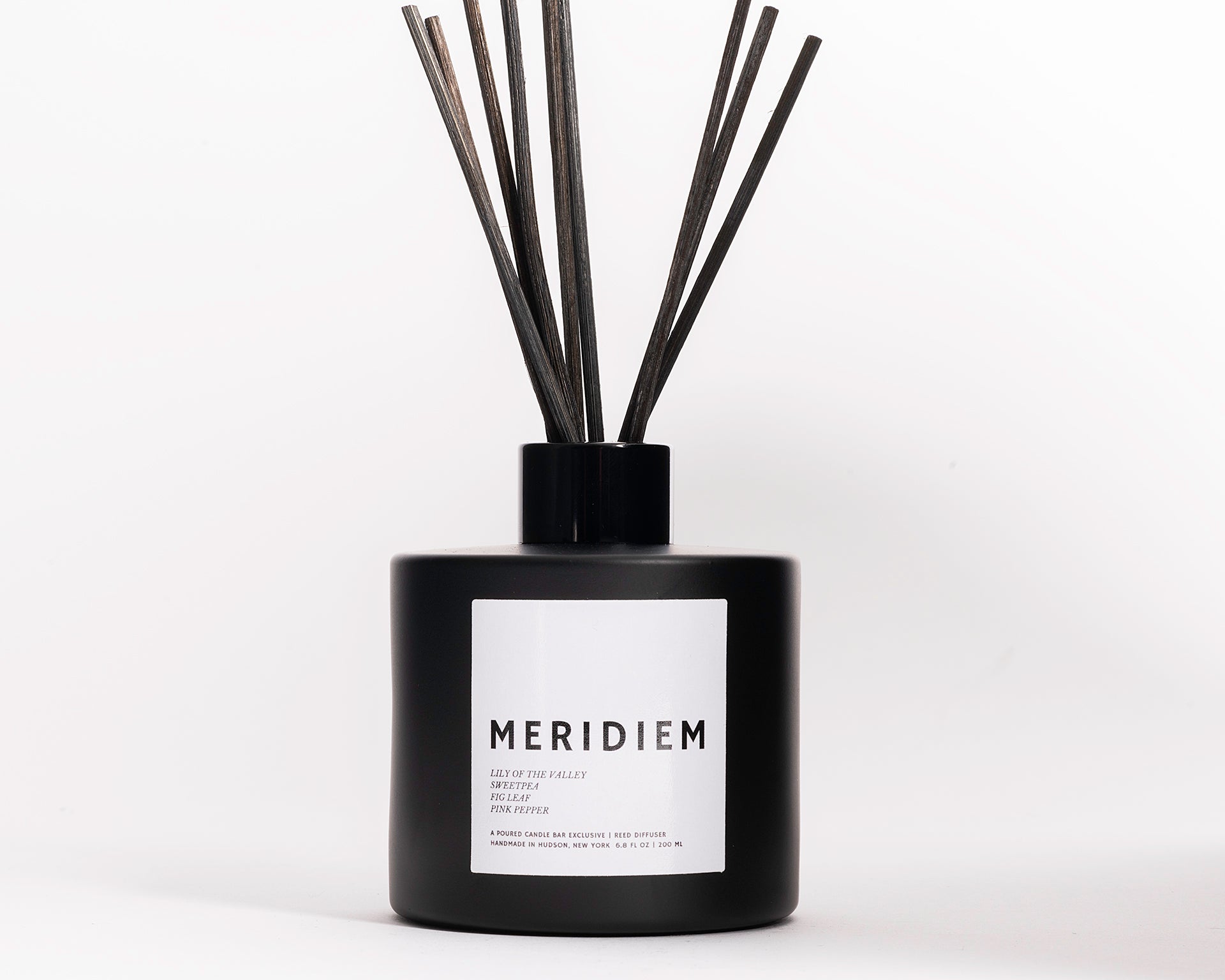 200 ml reed diffusers in a black circular glass vessel.  Profile Description: Green grass with sweet fruit + soft spice  Notes: Aldehydes, Lilly of the Valley, Grass, Sweet Pea, Fig Leaf, Pink Peppercorn